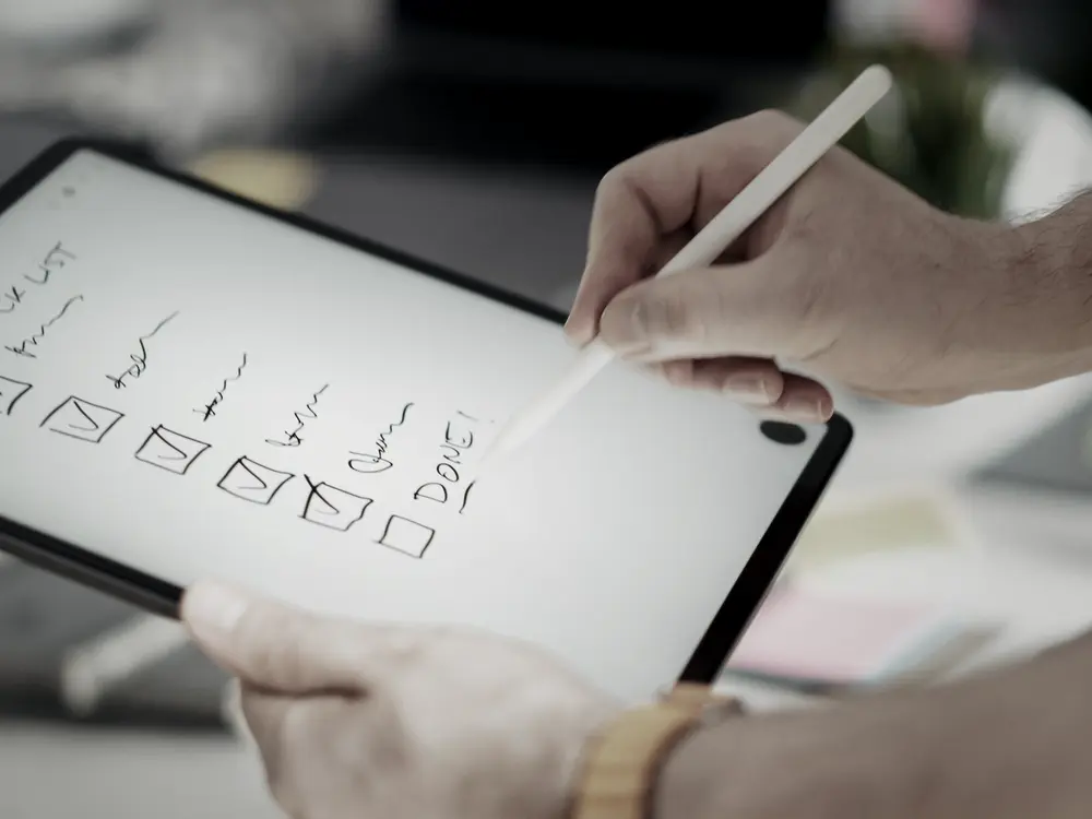Hand ticking a checklist on a tablet